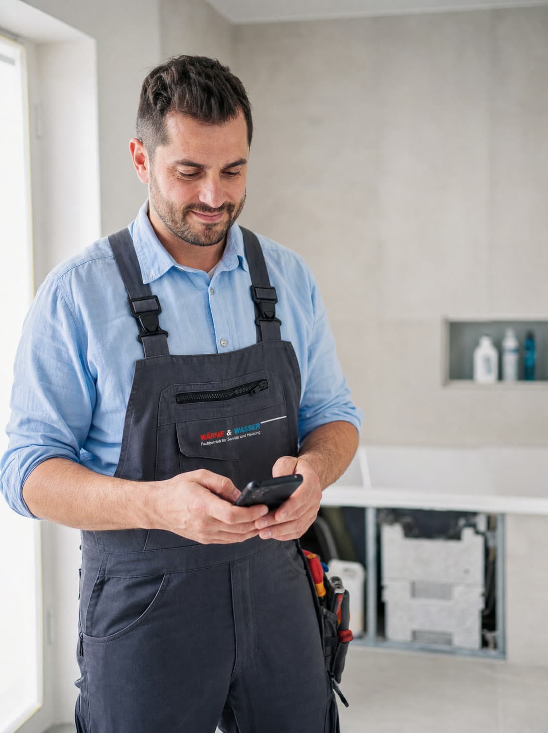 Handwerker erfasst Zeiten am Handy